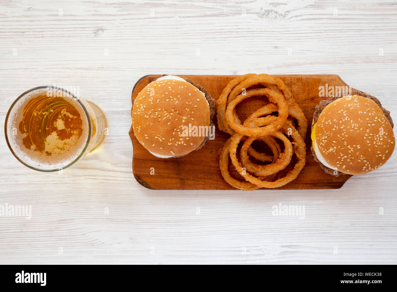 Vue de dessus, des limaces Mississippi hamburgers avec des oignons et un verre de bière fraîche sur un fond de bois blanc. Mise à plat, à partir de ci-dessus, les frais généraux. Banque D'Images