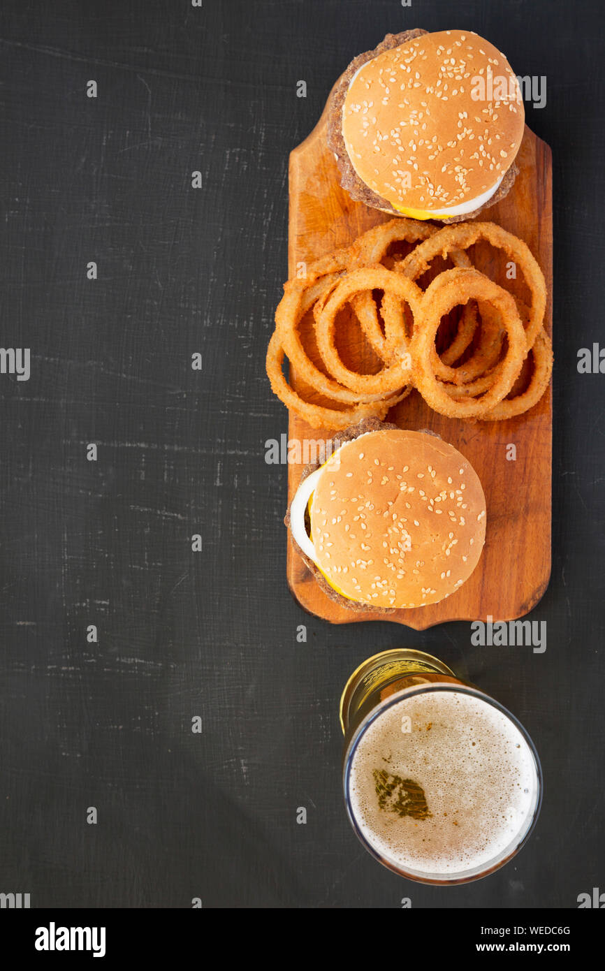 Des limaces Mississippi hamburgers avec des oignons sur une planche en bois rustique sur un fond noir, vue du dessus. Mise à plat, les frais généraux, d'en haut. Savs copie Banque D'Images