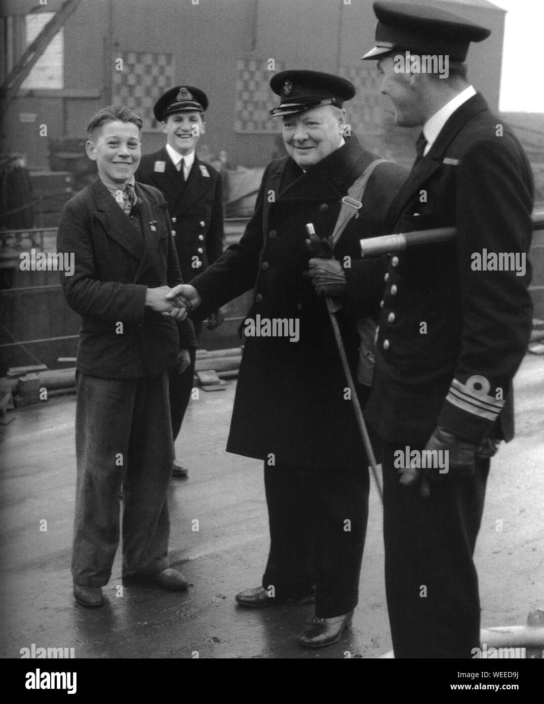 Winston Churchill entre la main avec un jeune ouvrier de chantier naval au chantier naval de Portsmouth. 1941. Banque D'Images