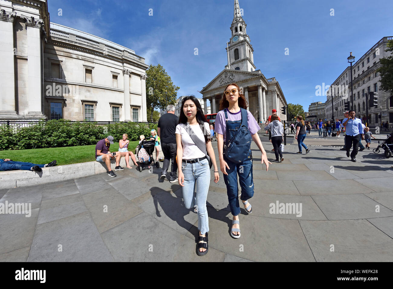 Londres, Angleterre, Royaume-Uni. Deux touristes japonais à Trafalgar Square Banque D'Images