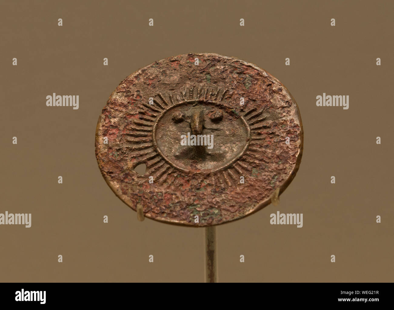 Le visage humain et motif soleil miroir en bronze. 3800 - 3600 il y a des années. Le Musée de la région autonome Uygur du Xinjiang. Banque D'Images