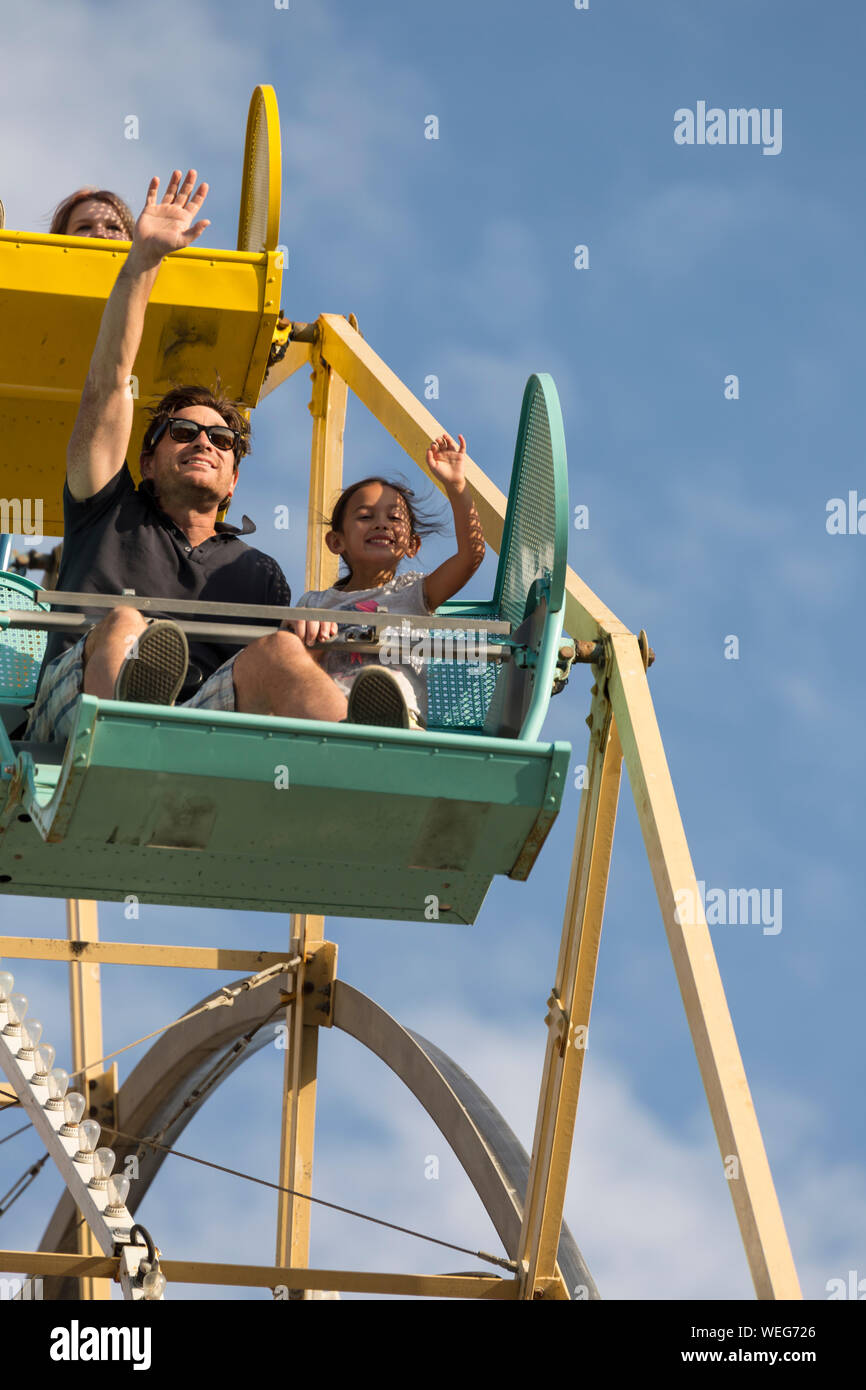 Père de race blanche avec l'origine ethnique mixte 9 ans le ride at fun-fair, Santa Cruz, Californie Banque D'Images