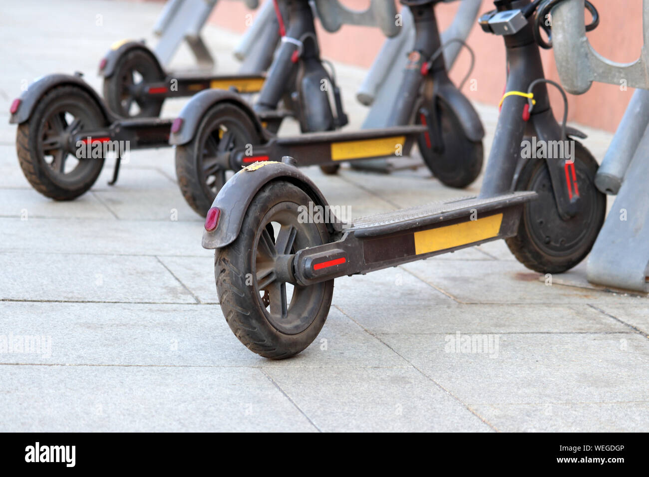 Des scooters électriques en stationnement sur une rue d'une journée ensoleillée. Eco-friendly transport, e-scooters sur parking Banque D'Images