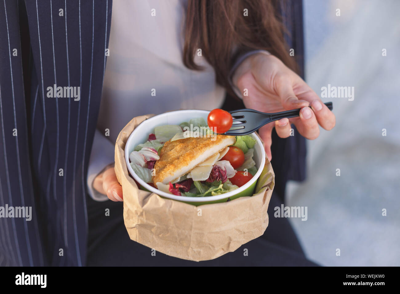 Salade dans un déjeuner d'affaires. Mains de business woman holding de légumes grillés et de la fourchette. Banque D'Images
