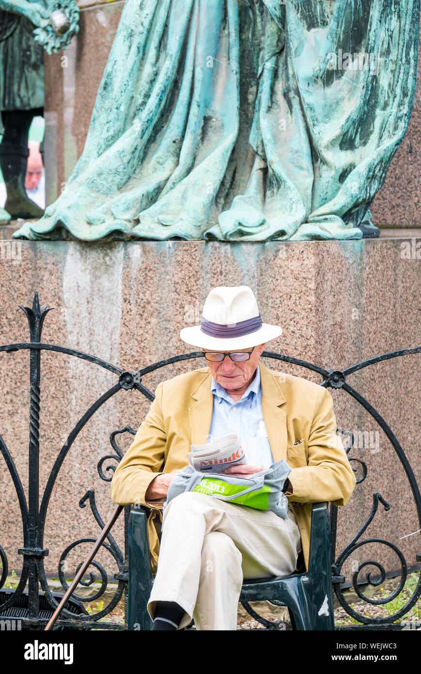 Homme avec Chapeau Panama la lecture de la sculpture pendant l'Edinburgh International Book Festival, Charlotte Square Garden, Ecosse, Royaume-Uni Banque D'Images