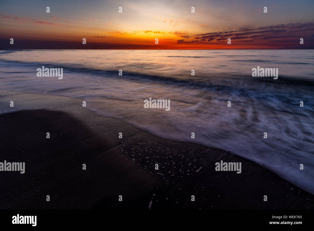 Ciel coloré sur la mer du Nord après le coucher du soleil sur la plage de Juist, îles de la Frise orientale, en Allemagne. Banque D'Images