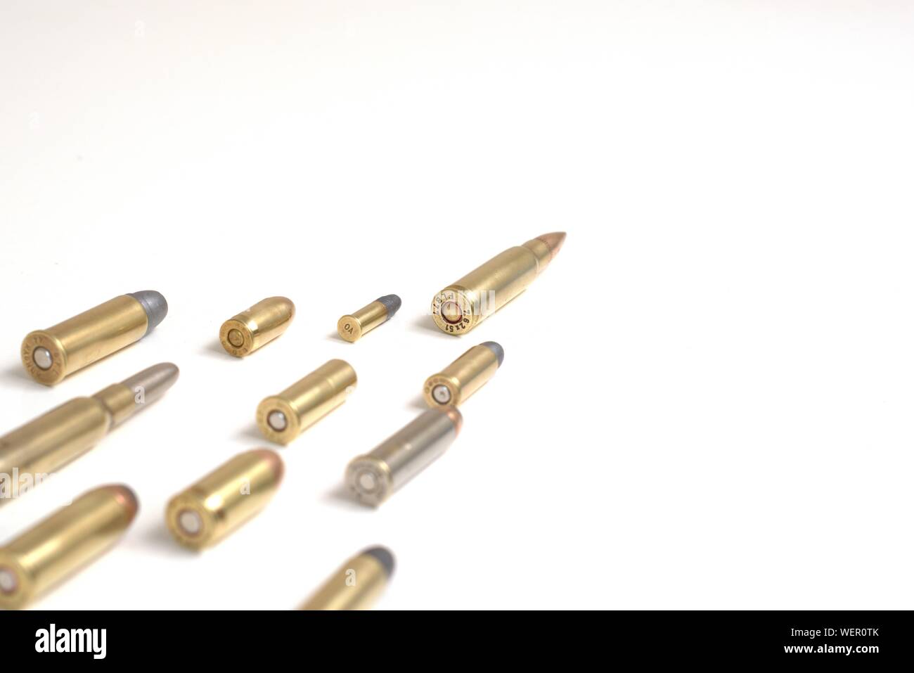 Un grand miracle menant plusieurs petites balles portant sur une surface blanche. Il fonctionne comme un concept pour le leadership, la criminalité, la course aux armements. Banque D'Images