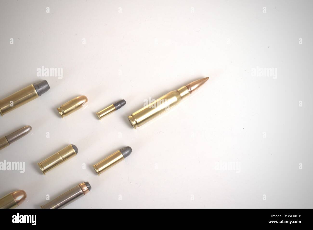 Grand bullet menant plusieurs petites balles portant sur une surface blanche. Il fonctionne comme un concept pour le leadership, la criminalité, la course aux armements. Banque D'Images