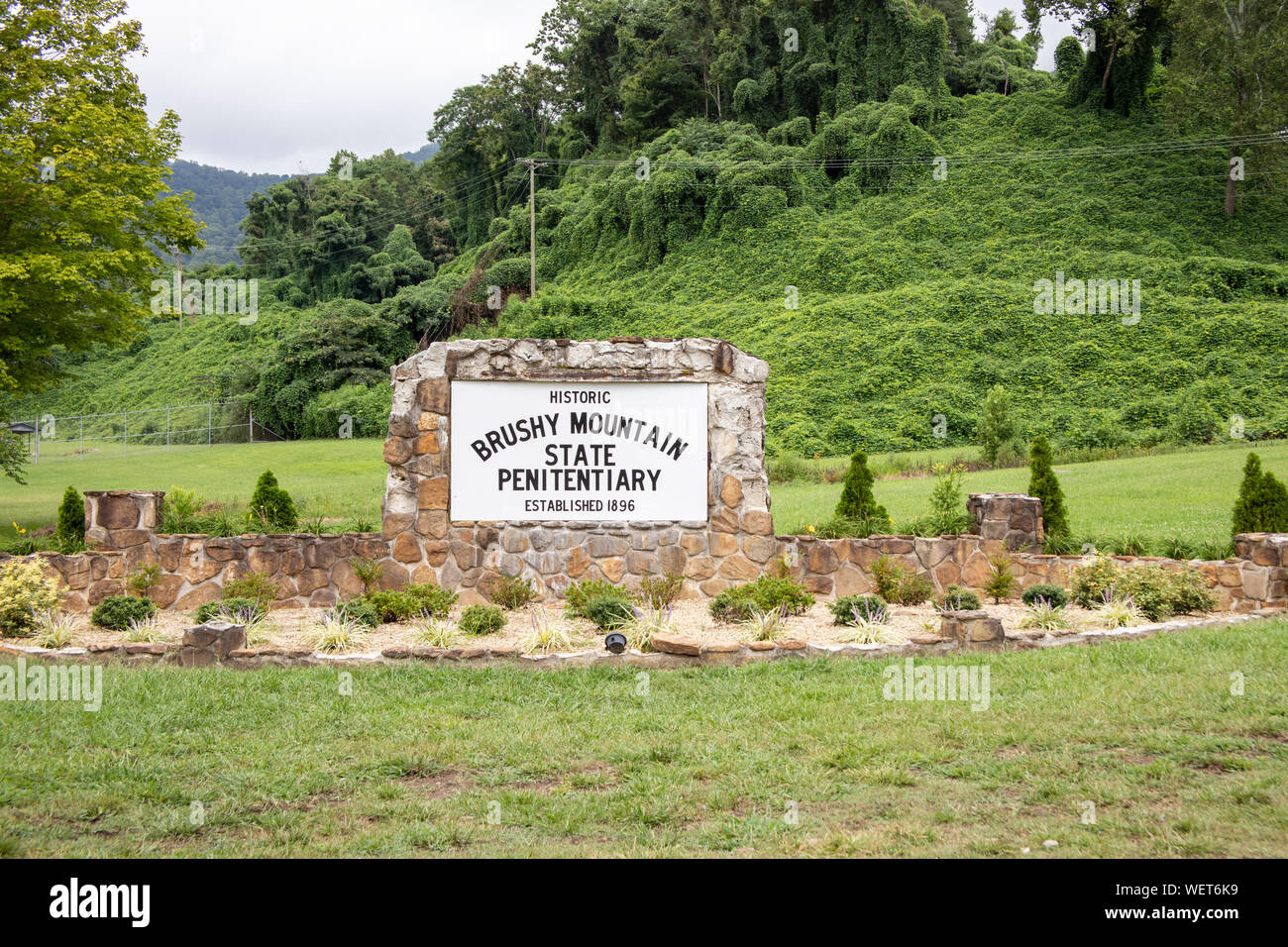 Petros, New York - 25 août 2019 : signe de l'entrée en pierre de montagne accueil broussailleux pénitencier de l'état de fin de la ligne Moonshine Distillery sur la T Banque D'Images