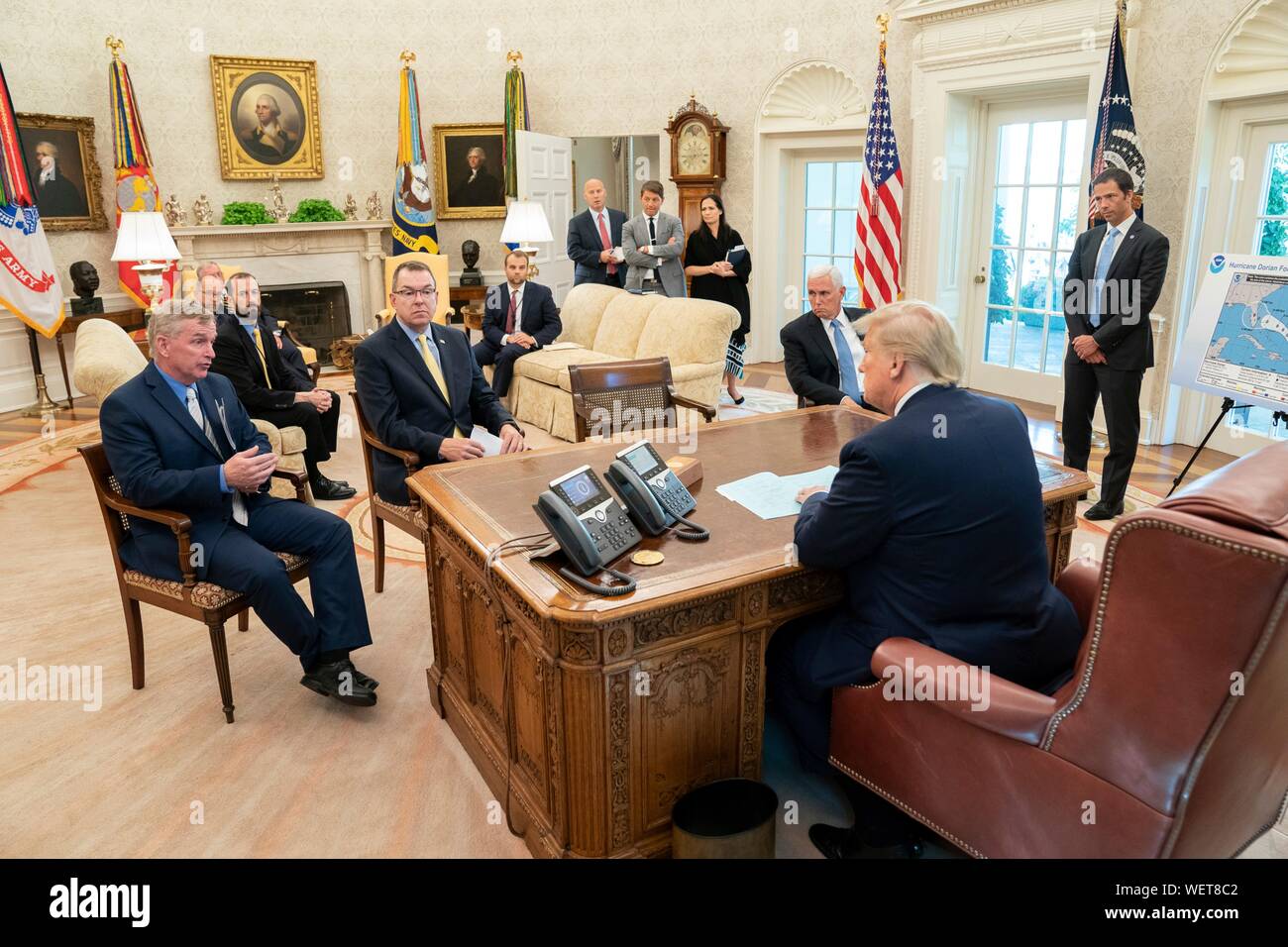 Washington, DC, USA. 29 août 2019. Le Président américain Donald Trump, rejoint par le Vice-président Mike Pence, reçoit un exposé sur l'Ouragan Dorian dans le bureau ovale de la Maison Blanche le 29 août 2019. La prévision actuelle appelle à Dorian pour renforcer au-dessus de l'eau à une catégorie 4 avec des vents de 140 mph avant de prendre les côtes de Floride du Sud fin lundi. Credit : Shealah Planetpix Craighead//Alamy Live News Banque D'Images