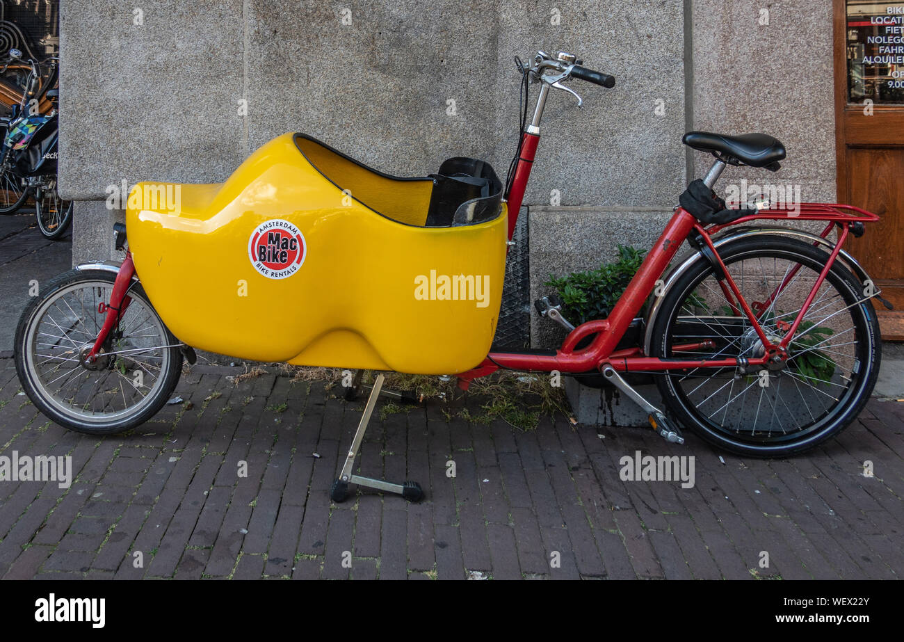 Amsterdam, Pays-Bas - 1 juillet 2019 : Libre de bakfiets en stationnement, à l'avant-tronc vélo pour transporter une charge ou un enfant. Tronc en forme de sabot jaune. Banque D'Images