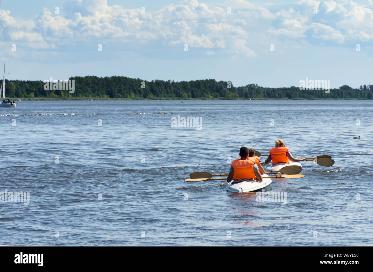 Deux kayaks sur le lac vue vers l'arrière. Les canoéistes vêtus de gilets orange. Banque D'Images