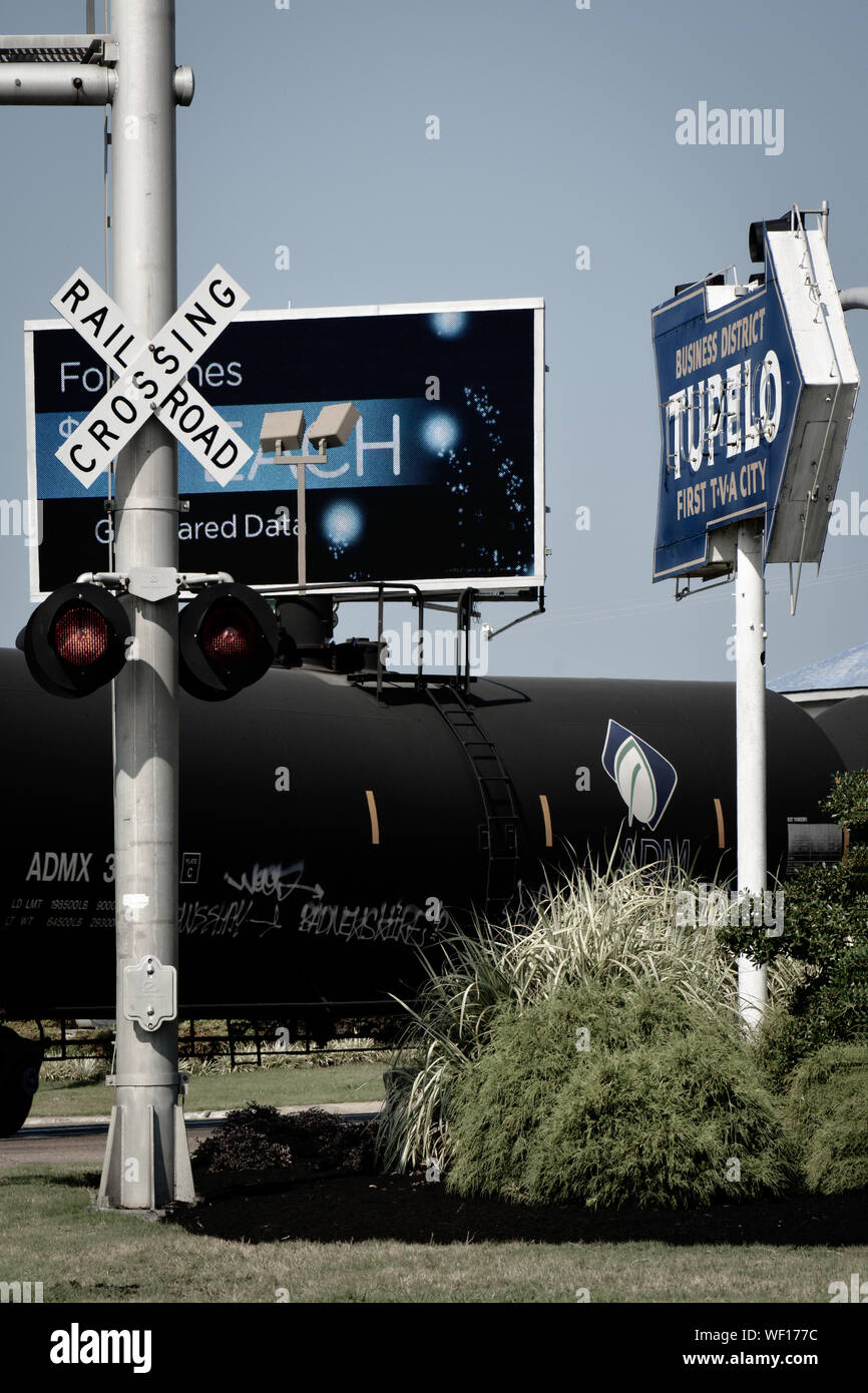 Railroad Crossing avec train de fret pétroliers tirant au carrefour centre-ville dans le quartier historique de Tupelo, MS, avec vintage Premier signe Ville TVA Banque D'Images