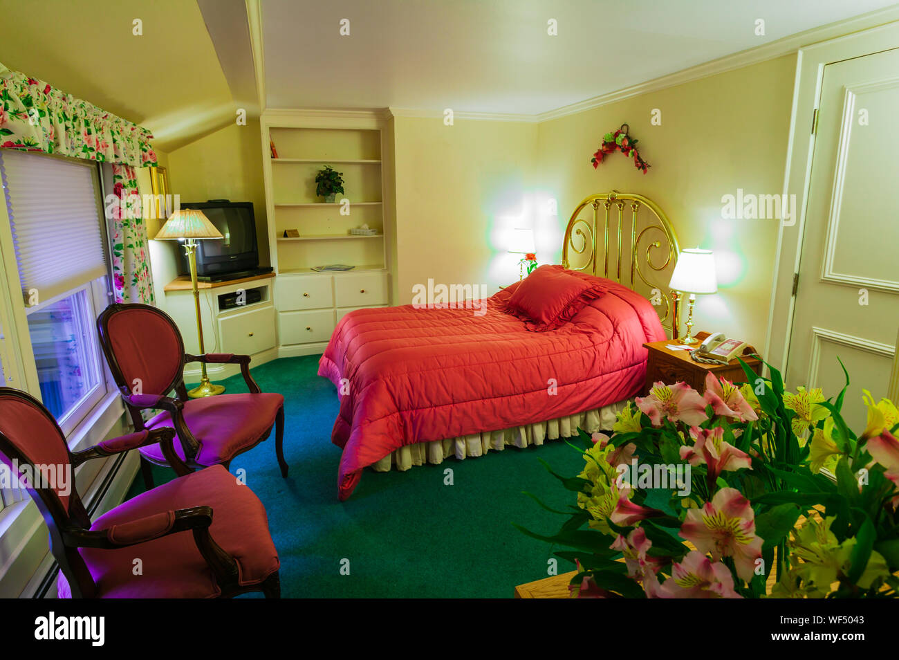 Hôtel haut de gamme, chambre avec un lit en laiton et fleurs. Banque D'Images