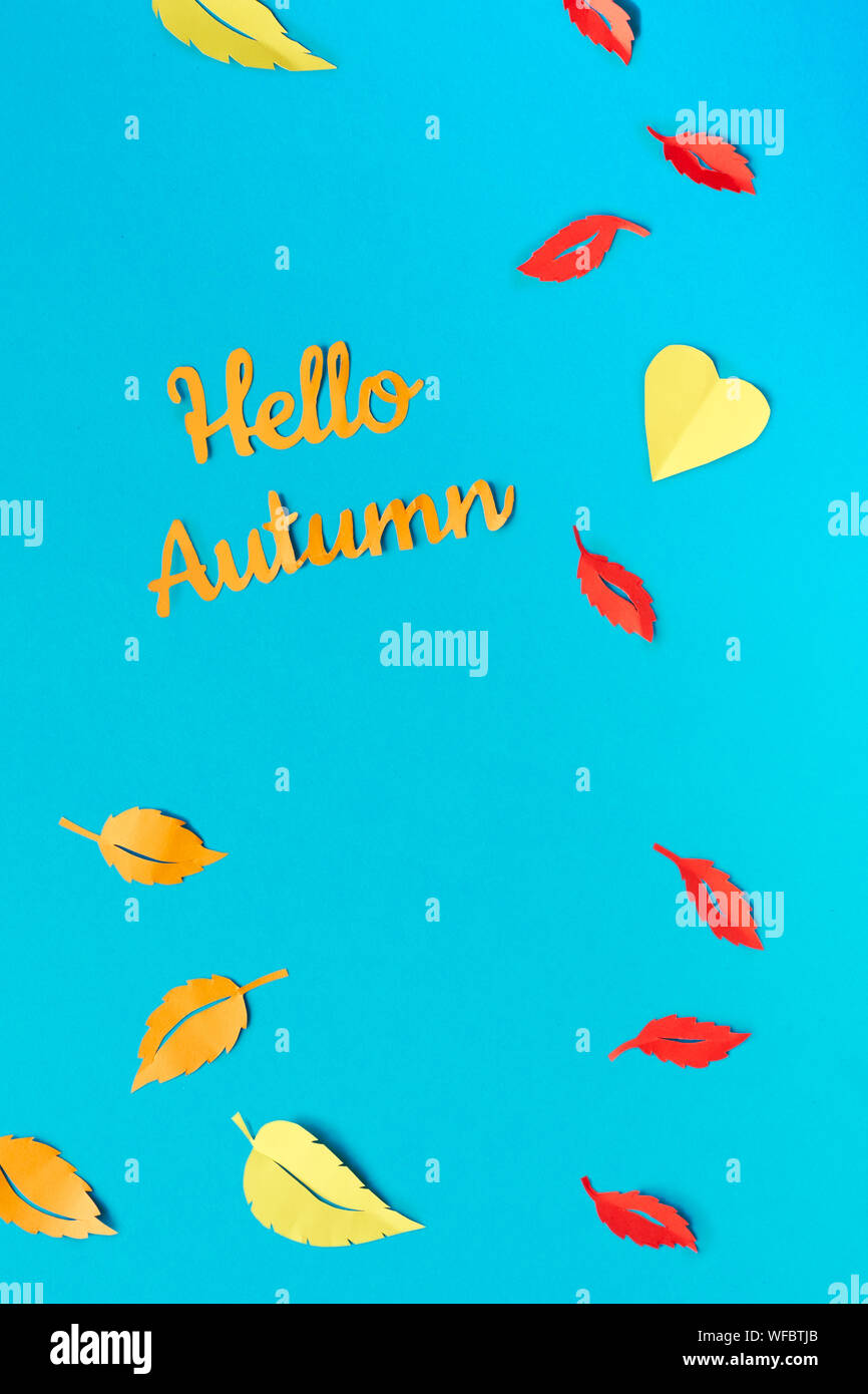 Créations en papier, feuilles d'automne jaune et rouge, télévision jeter sur papier bleu fond, du texte 'Bonjour' Banque D'Images