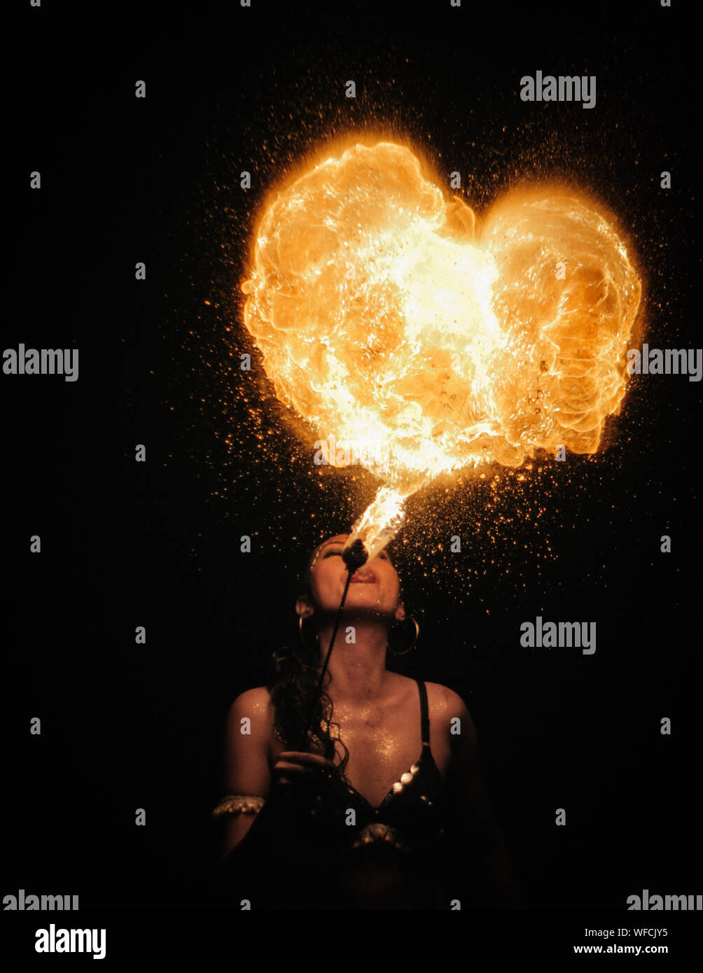 Woman Blowing forme de coeur d'artifice dans la nuit Banque D'Images