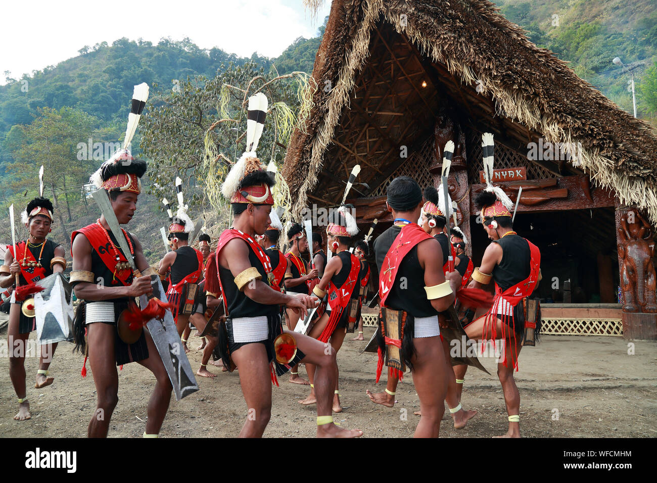 Des tribus Naga Konyak de tribu exécuter une danse devant leur hutte traditionnelle sur Hornbill Festival, Nagaland, Inde Banque D'Images