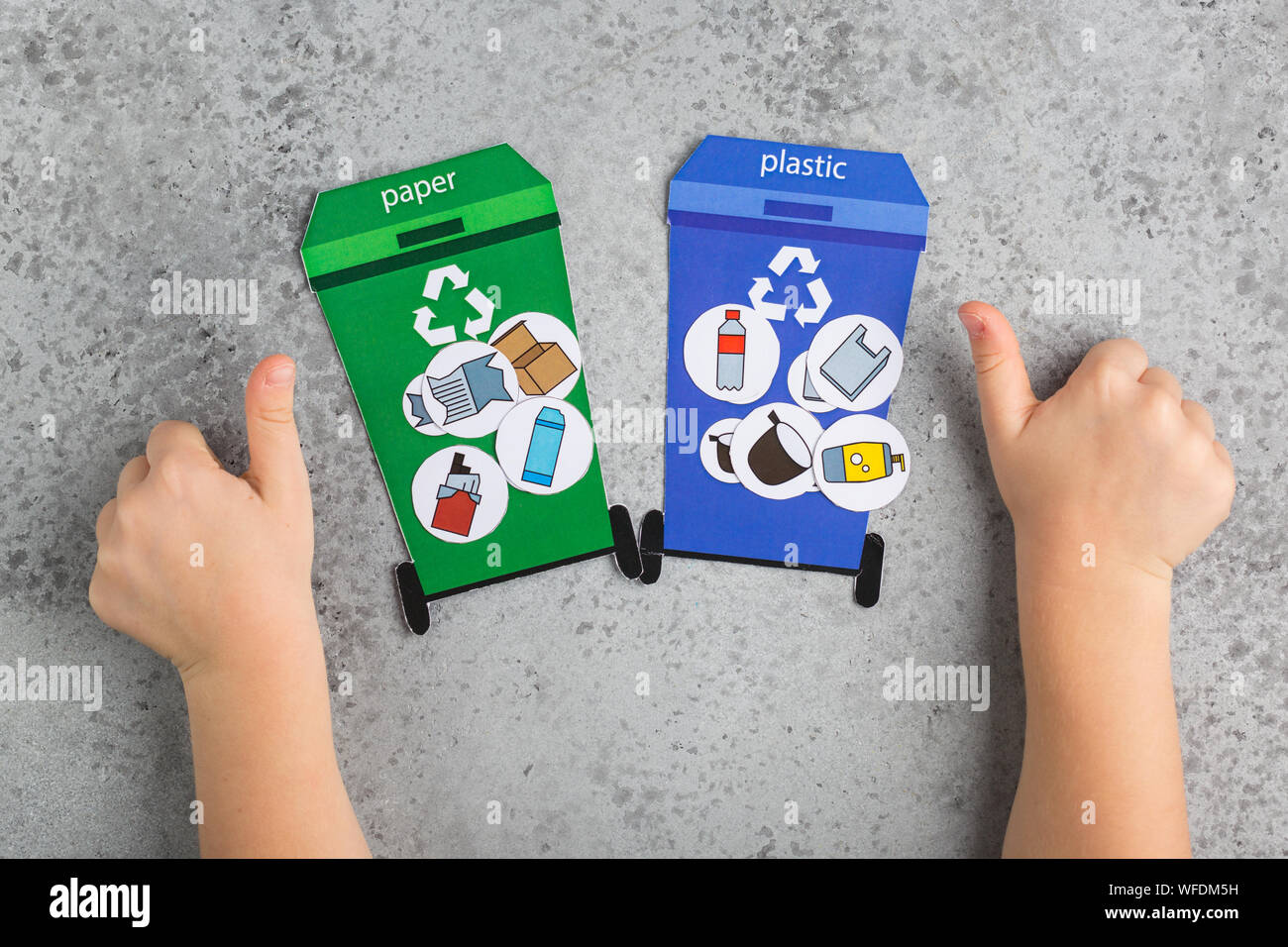 La conception de jeu de recyclage pour les enfants fille mains éducation écologie concept de recyclage des déchets Banque D'Images