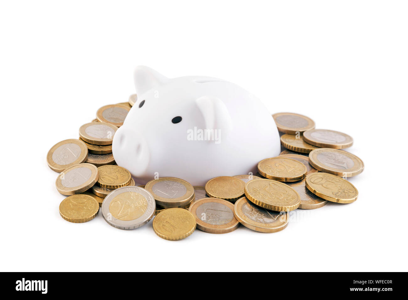 White piggy bank avec les pièces en euros sur fond blanc Banque D'Images