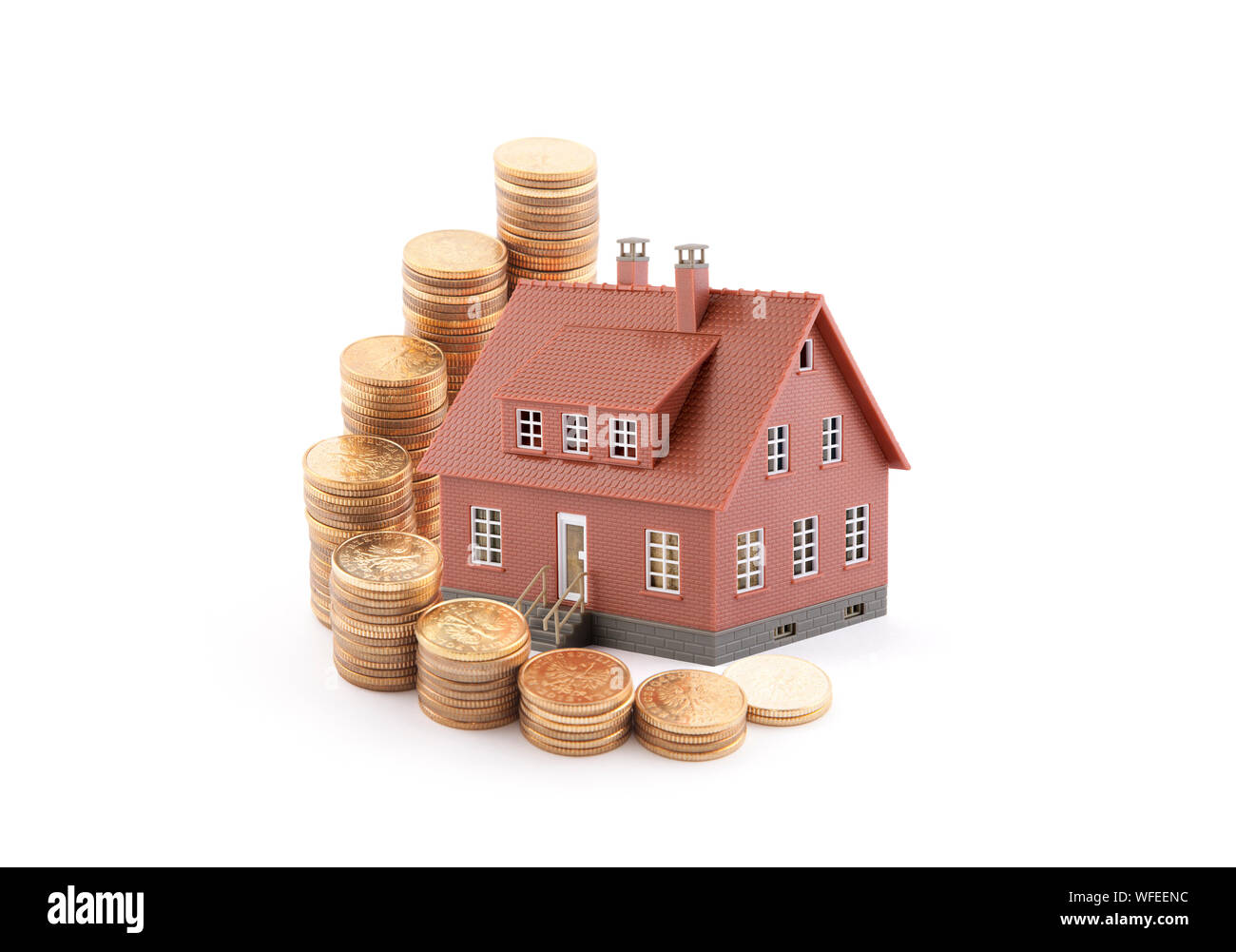 Investir dans l'immobilier concept. Petit jouet brun maison avec pièces d'or Banque D'Images