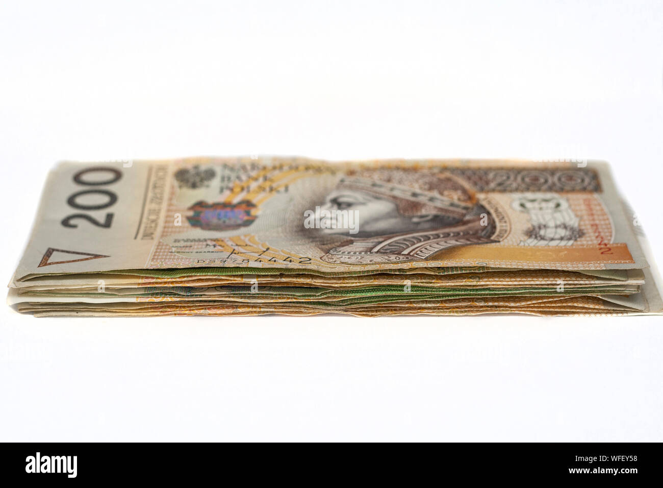 Pile de billets polonais avec deux cent billets zloties sur le dessus sur fond blanc Banque D'Images