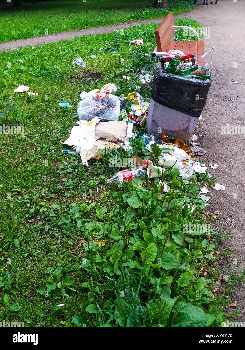 Corbeille pleine dans le parc à côté de l'établi. Banque D'Images