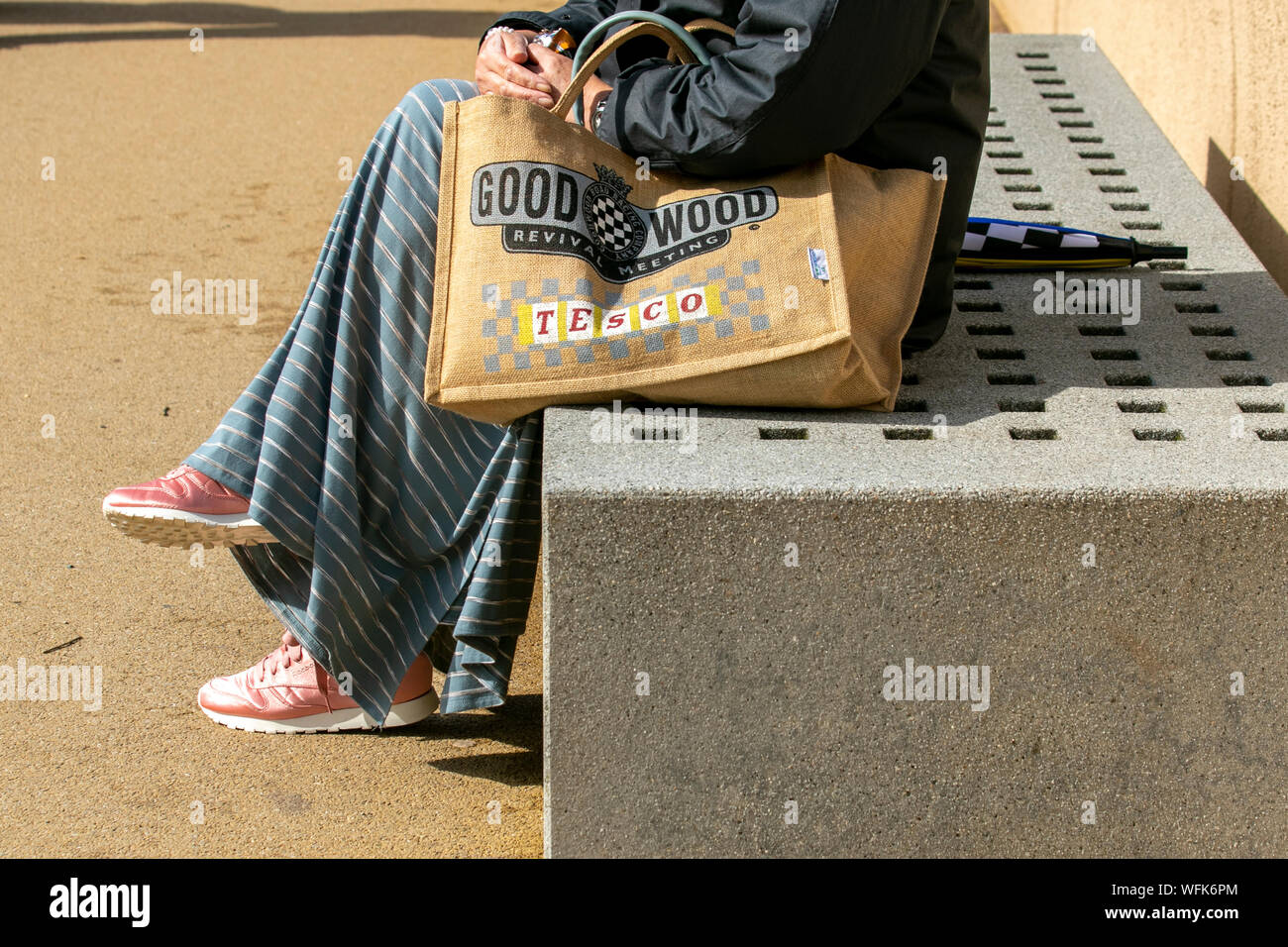 Femme assise tenant le sac de jute de Tesco pour la vie, publicité Goodwood Revival Meetinbg Festival, à Blackpool, Royaume-Uni Banque D'Images