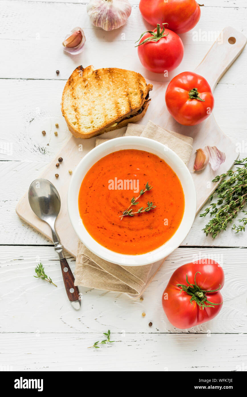 Soupe de tomate avec sandwich au fromage, vue du dessus, copiez l'espace. Soupe aux tomates maison avec le thym. Banque D'Images