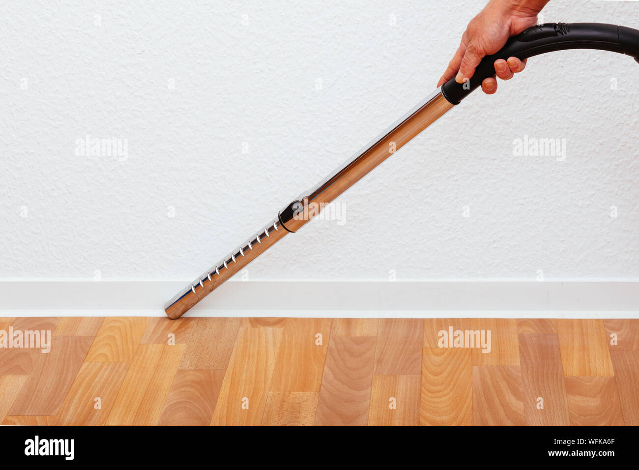 Cropped Hand Holding aspirateur contre mur blanc Photo Stock - Alamy