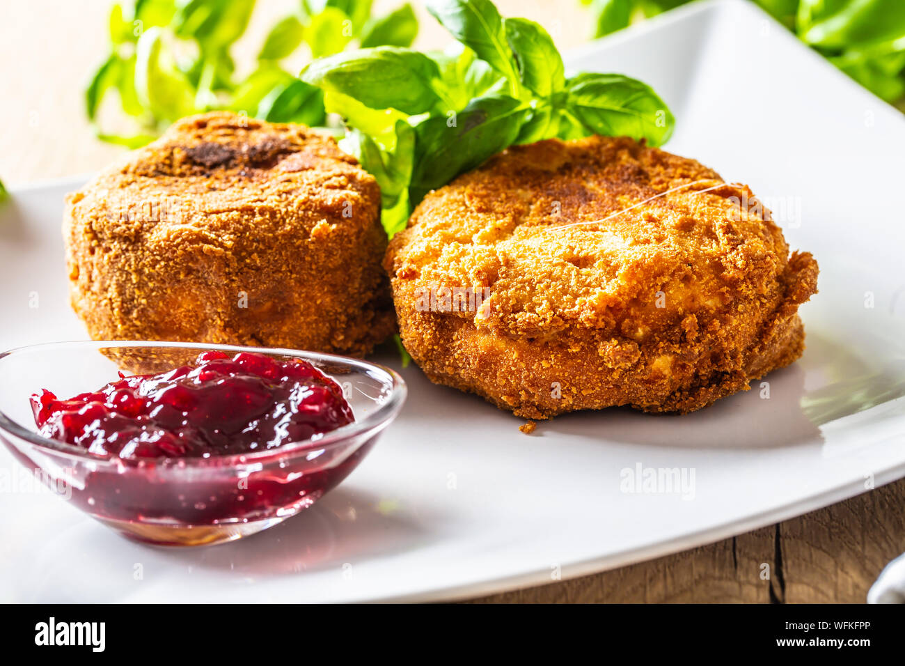 Le camembert ou le brie frit avec de la confiture de canneberges et basilic Banque D'Images