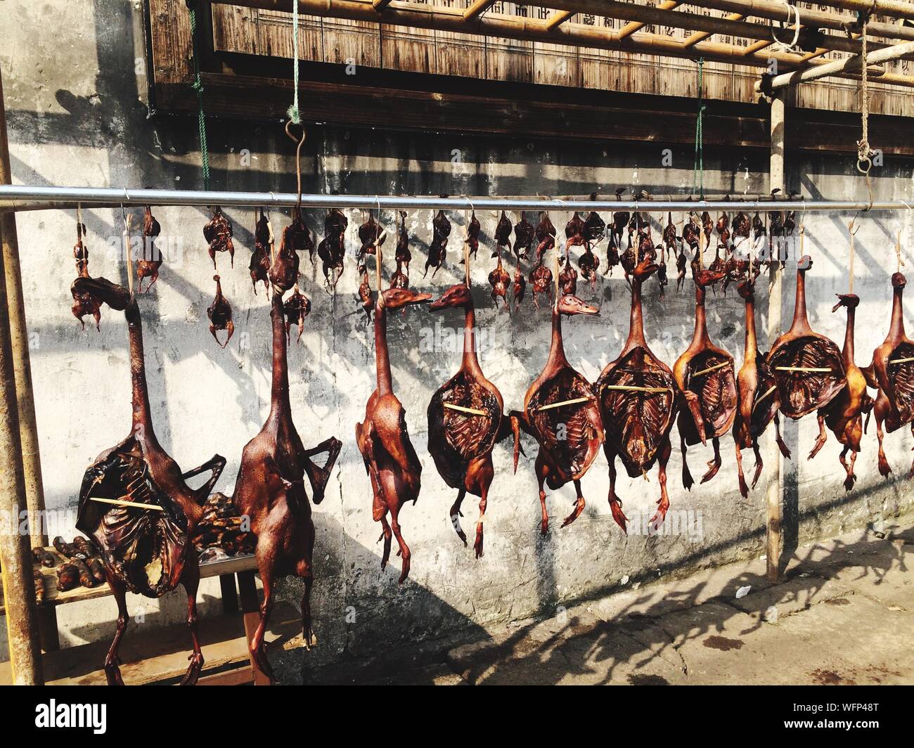 Les canards rôtis pendaison par Wall at Market Stall Banque D'Images