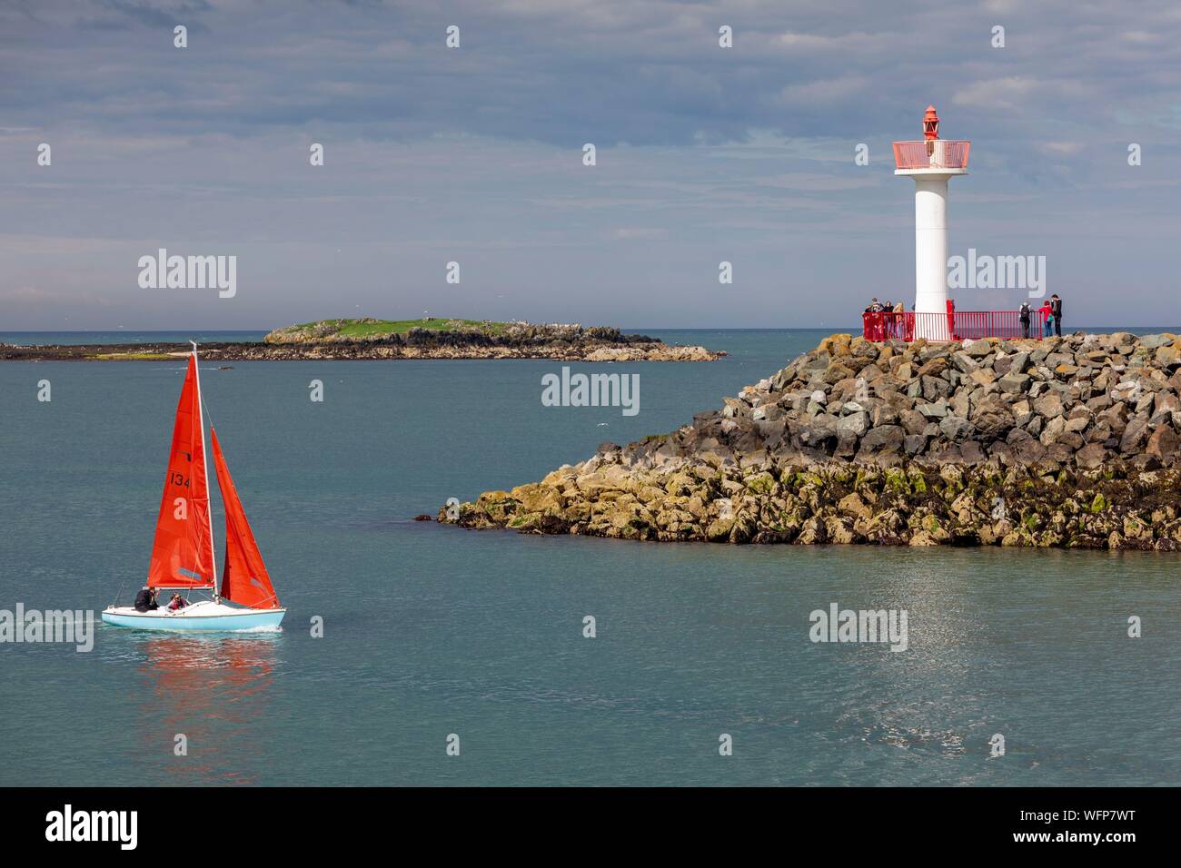 L'Irlande, le comté de Fingal, banlieue nord de Dublin, Howth, voilier entrant dans le port, en passant devant le phare balise Banque D'Images