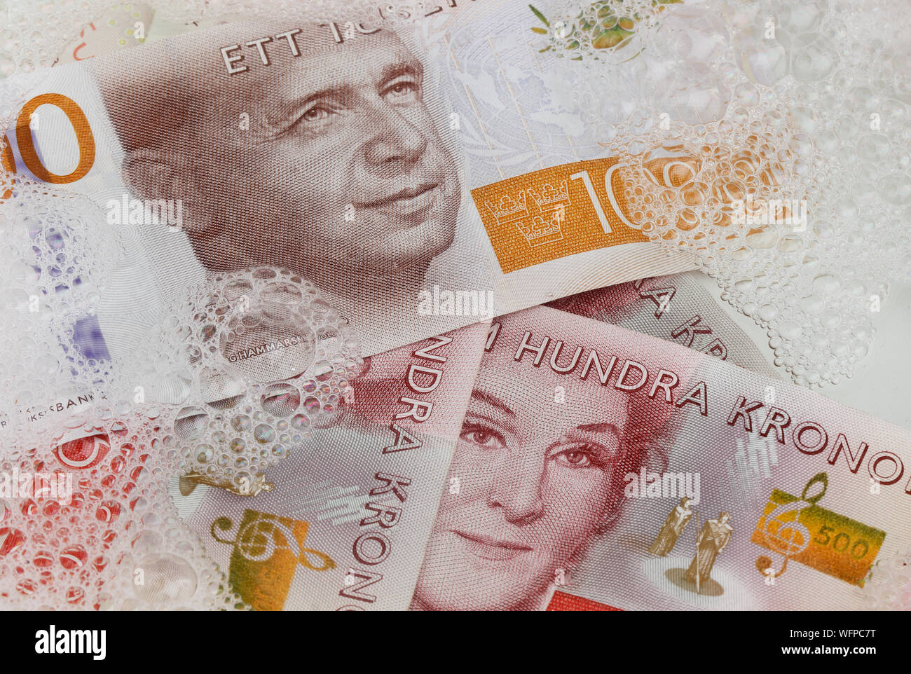 Stockholm, Suède - le 10 août 2019 : Swedish billets en coupures de 500 et 1000 couronne suédoise dans le blanchiment de l'eau avec du savon. Banque D'Images