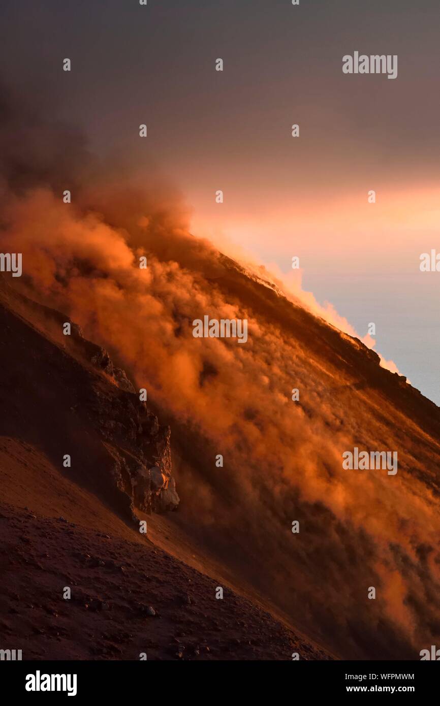 Italie, Sicile, Îles Éoliennes, classé au Patrimoine Mondial de l'UNESCO, l'île de Stromboli, fumerolles d'une éruption et la chute de bombes de lave sur les pentes du volcan actif au coucher du soleil Banque D'Images