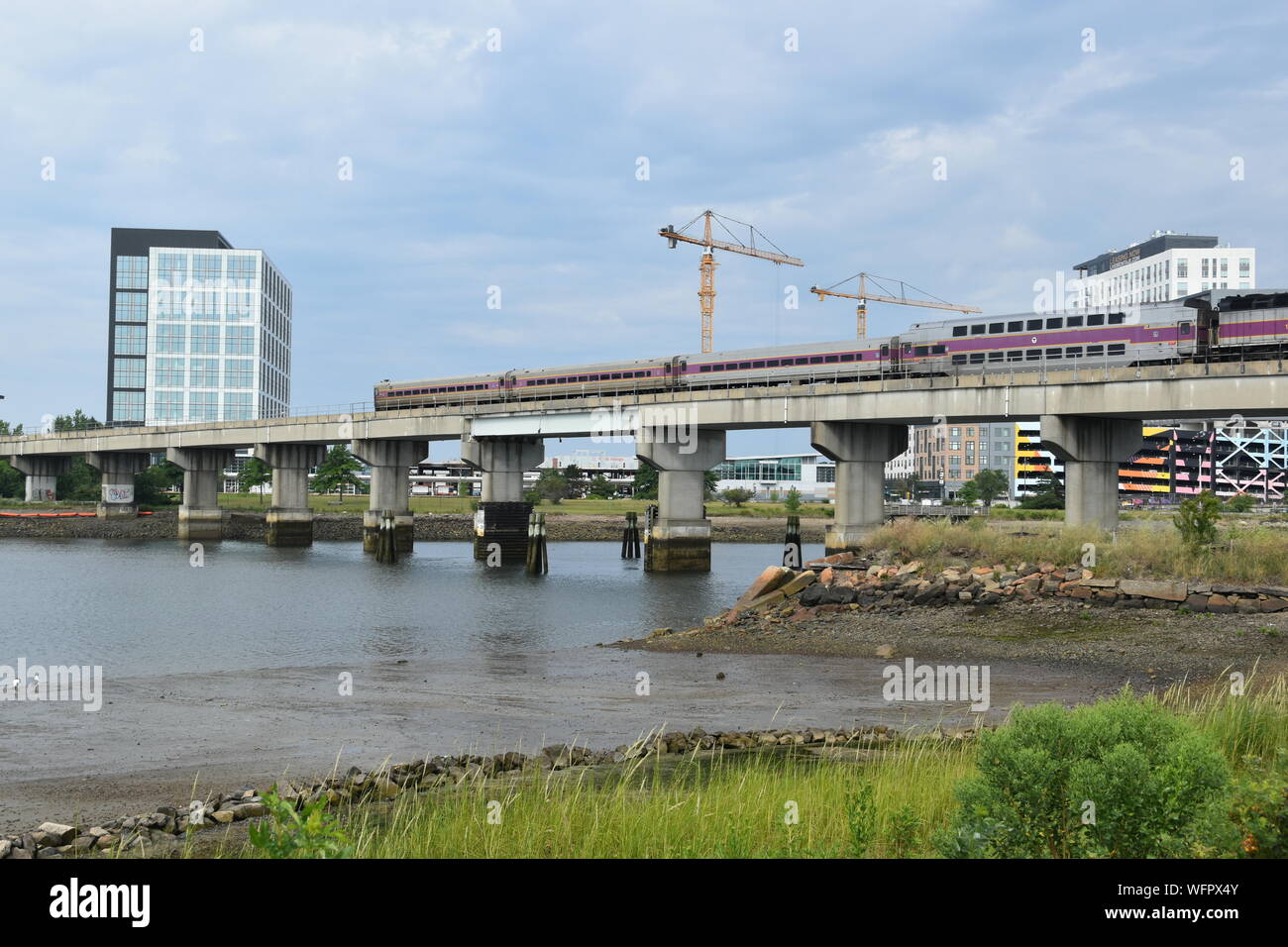 Un train de banlieue MBTA passant sur la Mystic River sur l'Newburyport/Ligne Rockport sur la côte nord de Boston, Massachusetts, USA Banque D'Images