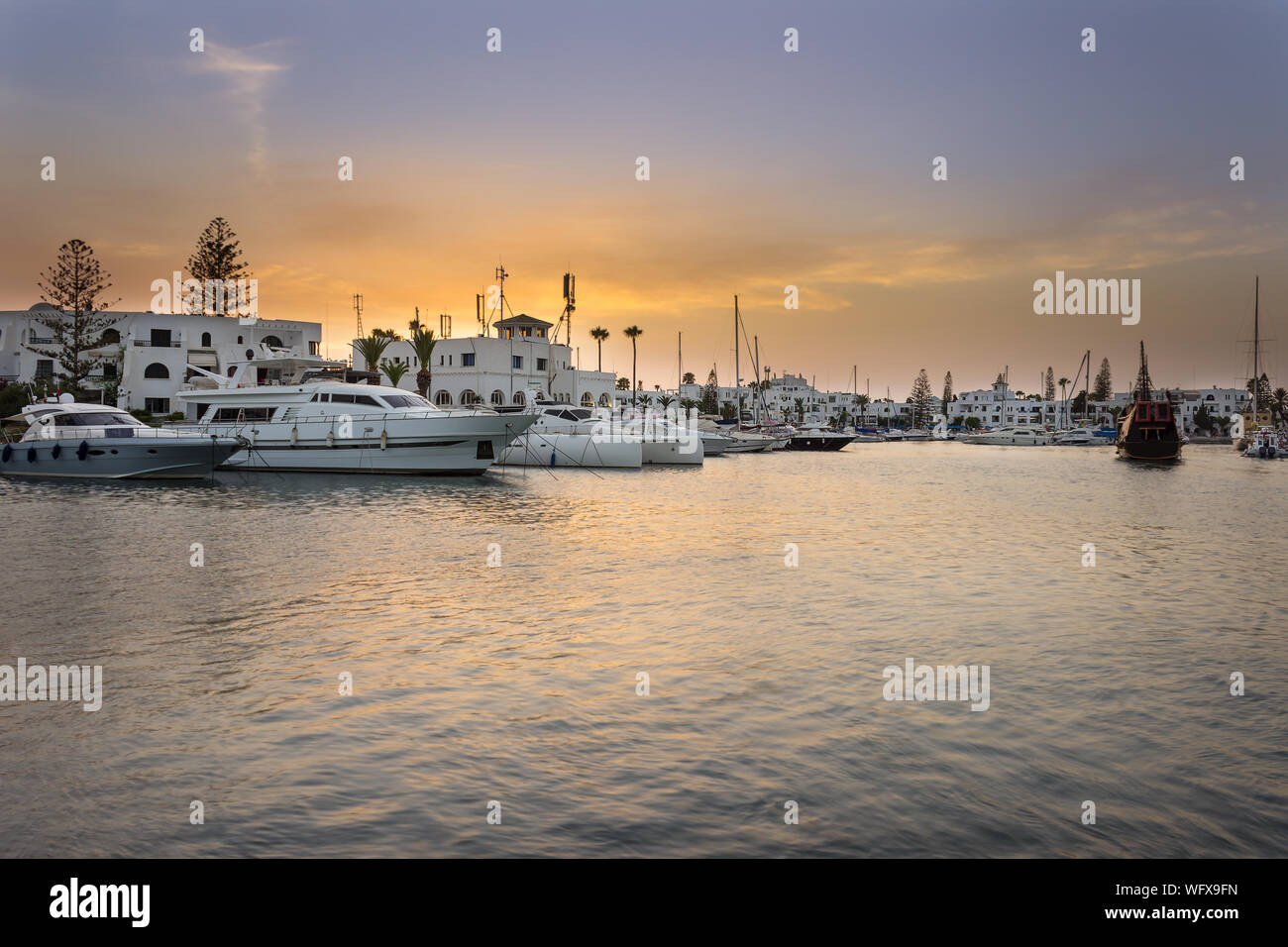 Amazing marina à Port El Kantaoui, Tunisie, colorée et bleu ciel doré, reflets dans la mer et beaux yachts et villas blanches et hôtels Banque D'Images