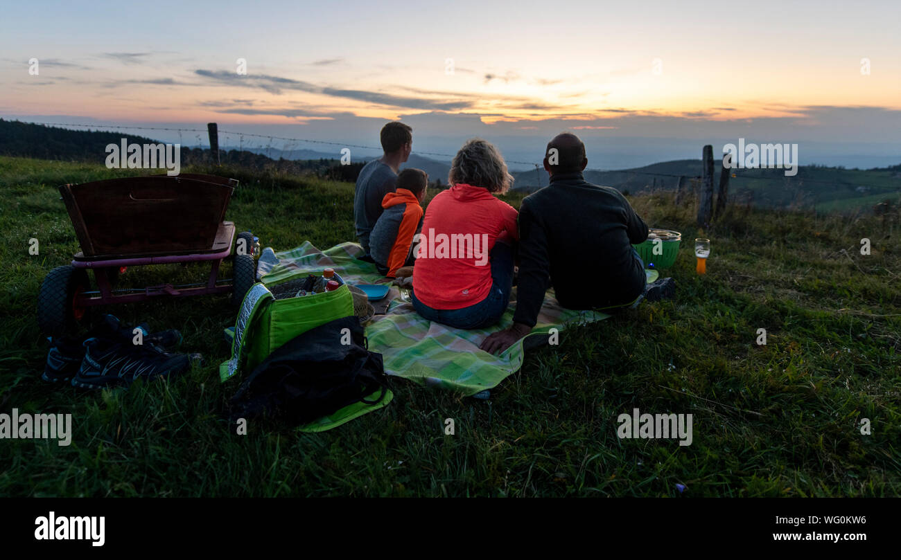 Bad Krozingen, Allemagne. Août 31, 2019. Une famille de la vallée de Münster est assis sur une couverture sur le Schauinsland, faire un barbecue et regarder le coucher du soleil. Crédit : Patrick Seeger/dpa/Alamy Live News Banque D'Images