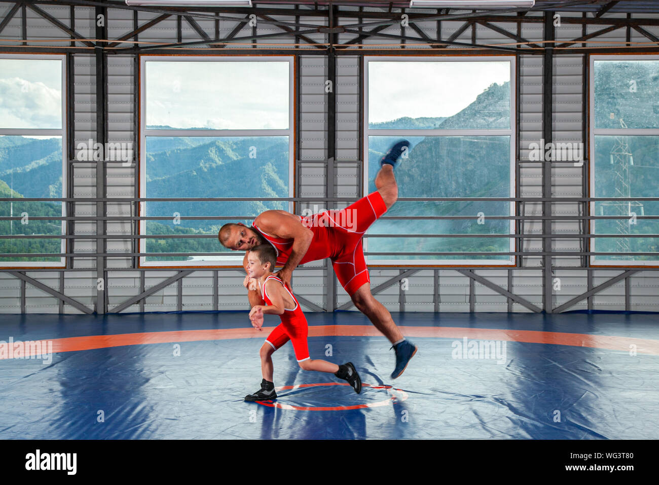 Le petit garçon dans le sport-sur le lutteur jette lutteur mâles adultes de la hanche sur un tapis de lutte dans la salle de sport. Le concept de l'alimentation de l'enfant et Marti Banque D'Images