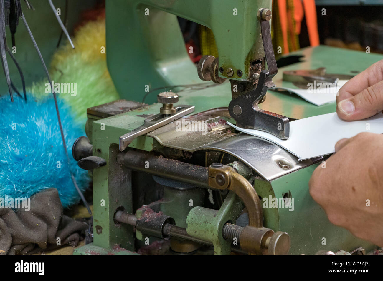Cordonnier de mains skiving cuir avec une machine du rabot vintage. Banque D'Images