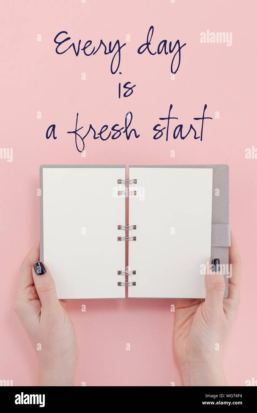 Télévision créative jeter vue du dessus de la main de l'ordinateur portable femme vide maquette sur fond rose avec texte de motivation chaque jour est un nouveau départ. Wr minimale Banque D'Images