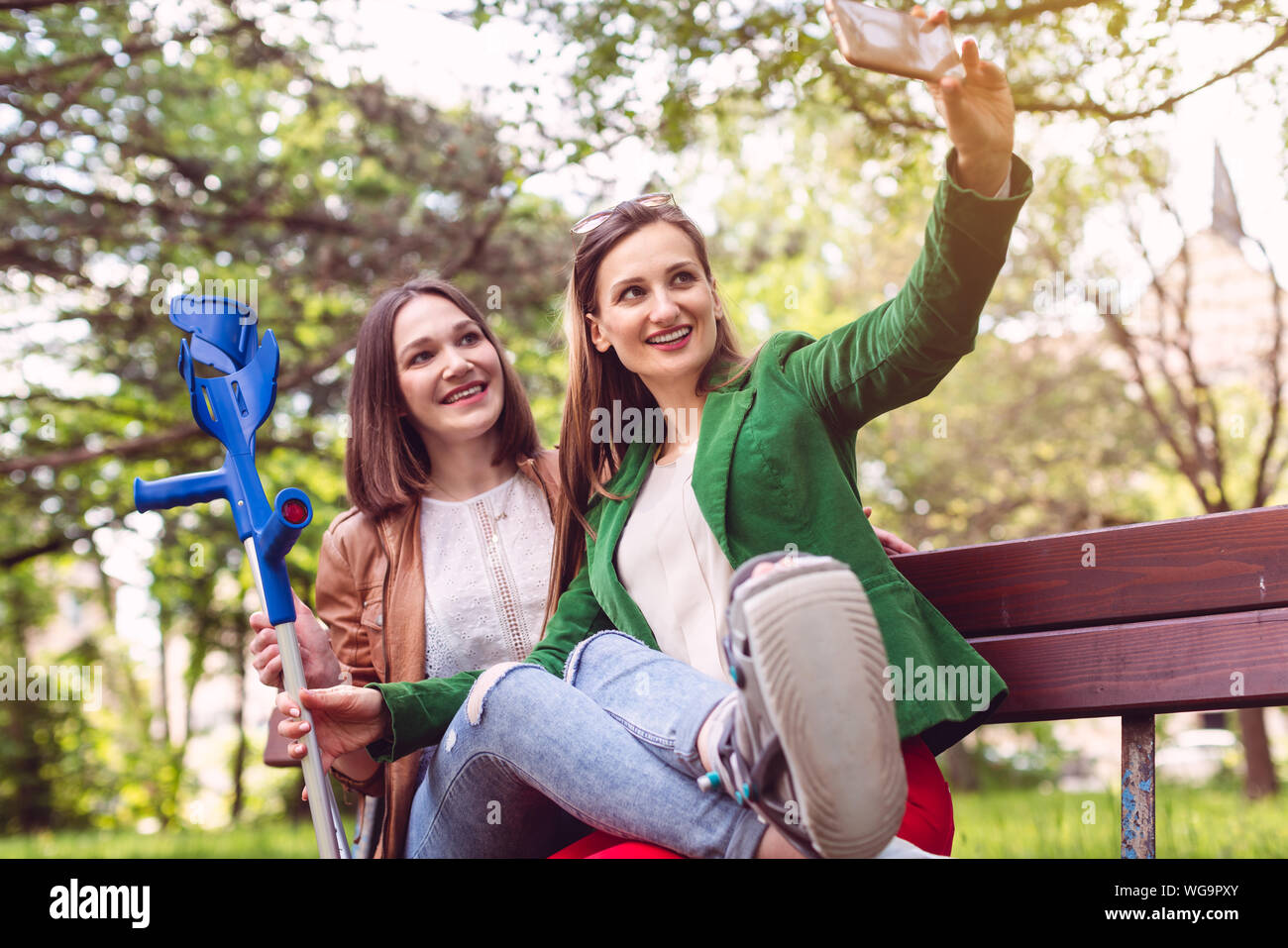 Femme et son ami avec une entorse à la cheville de la prise d'une photo Banque D'Images
