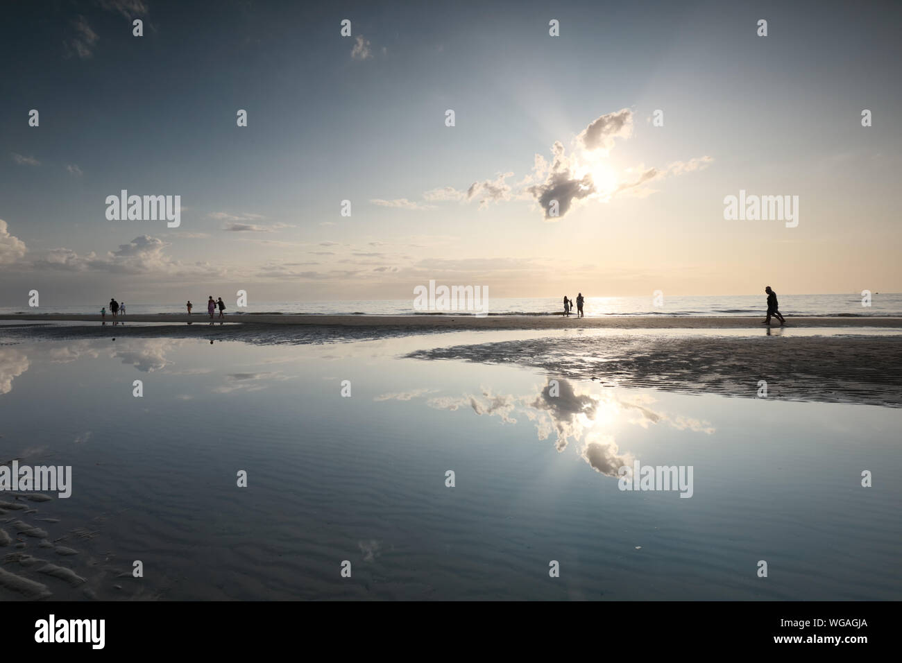 Les gens silhouettes sur la plage de sable de la mer sous le soleil en été Banque D'Images