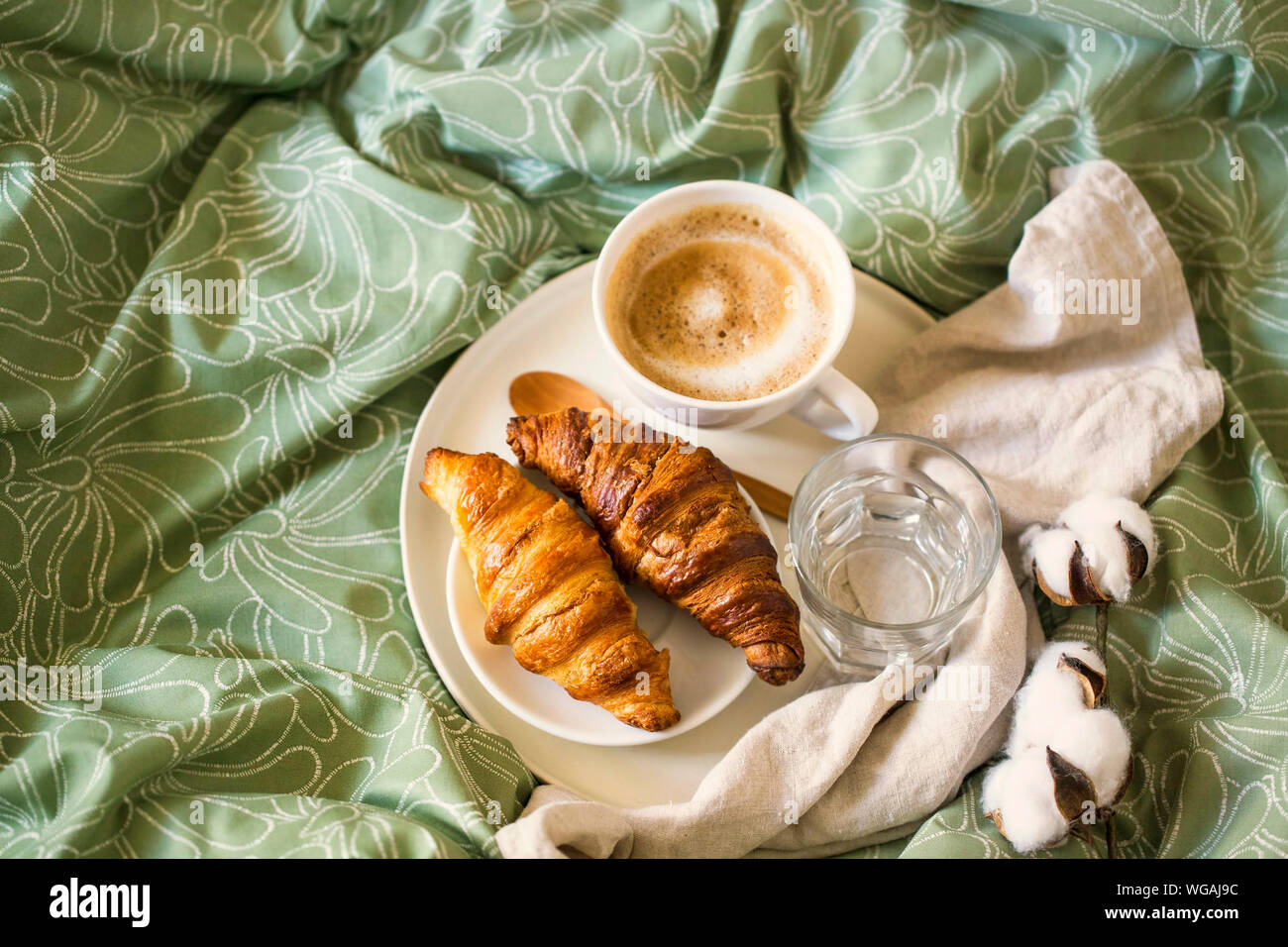 Matin petit déjeuner avec une tasse à café et croissants au lit. Vue d'en haut Banque D'Images