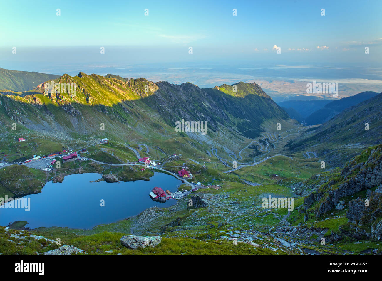 Scène à l'aube du lac Balea en Roumain des Carpates, lac, chalet et Transfarasan route sinueuse. Banque D'Images