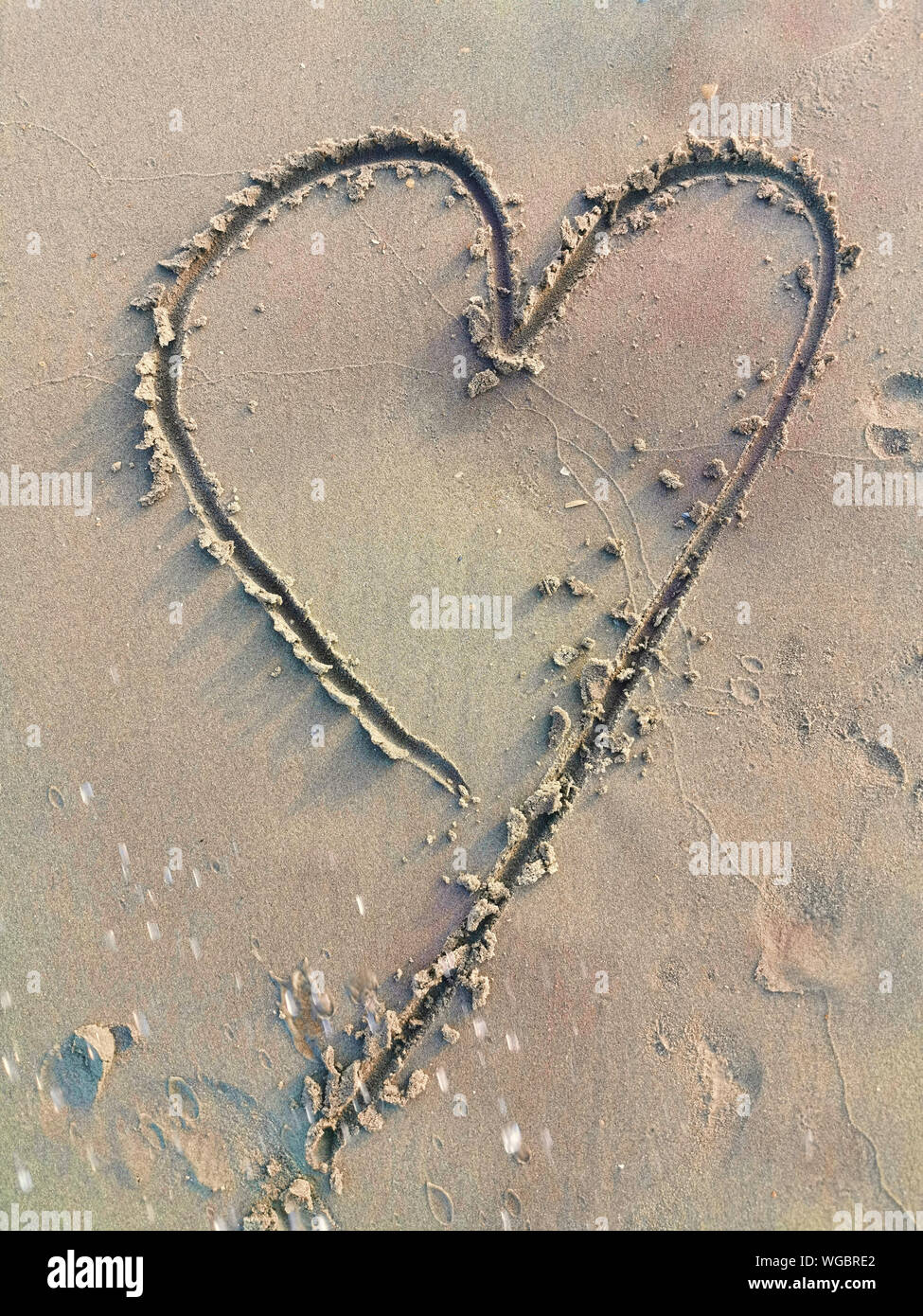 Symbole d'amour de dessin en plage de sable Banque D'Images