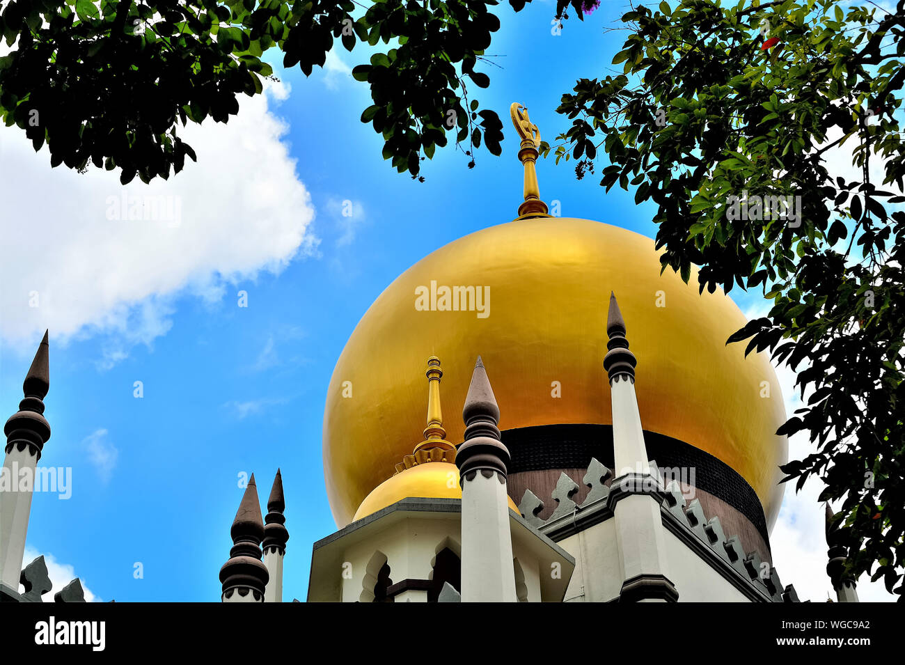 Vue en perspective du dôme doré et les minarets de la mosquée Masjid Sultan en arabe historique Street, Singapour contre ciel tropical bleu et entourée d'arbres Banque D'Images