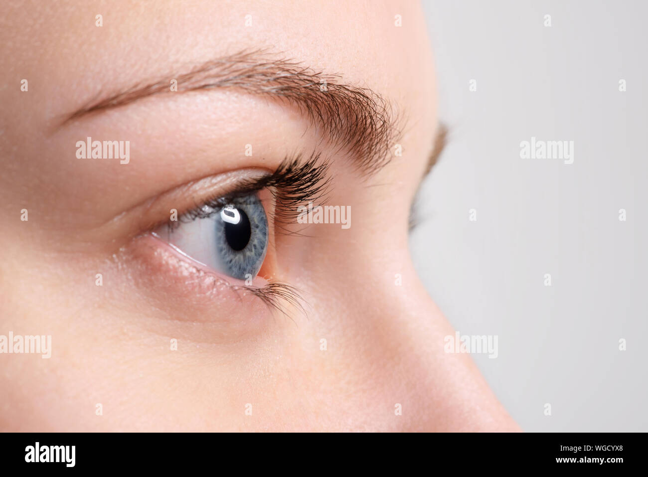 Close up blue eye avec maquillage naturel à la recherche sur le côté, macro shot avec la peau parfaite Banque D'Images
