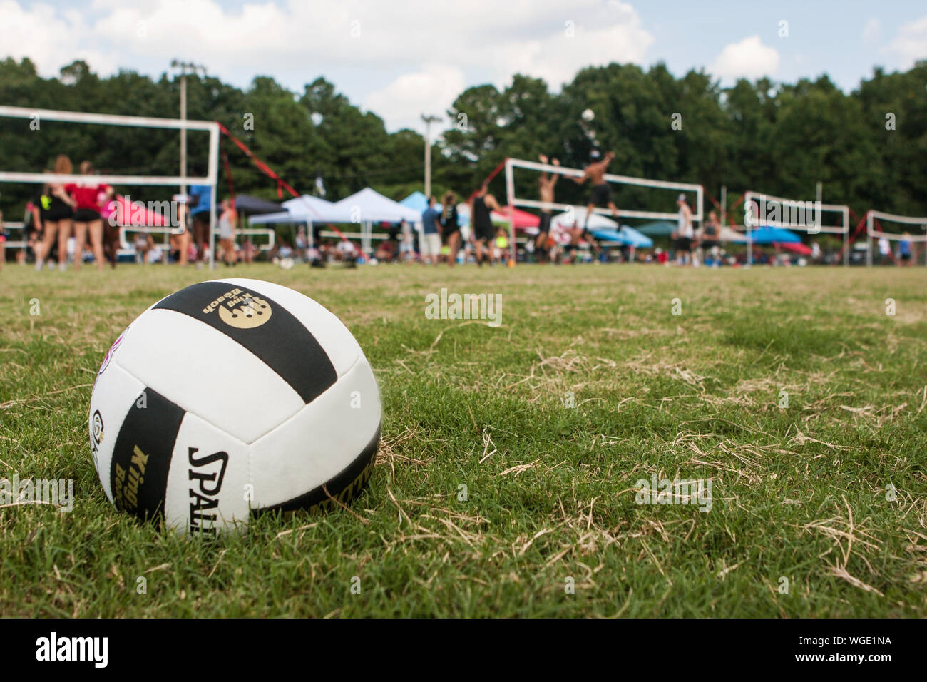 Faible angle plan large montre aux jeunes joueurs de volley-ball adultes participant à un tournoi de volley-ball de l'herbe tripler le 25 août 2019 à Doraville, Géorgie. Banque D'Images