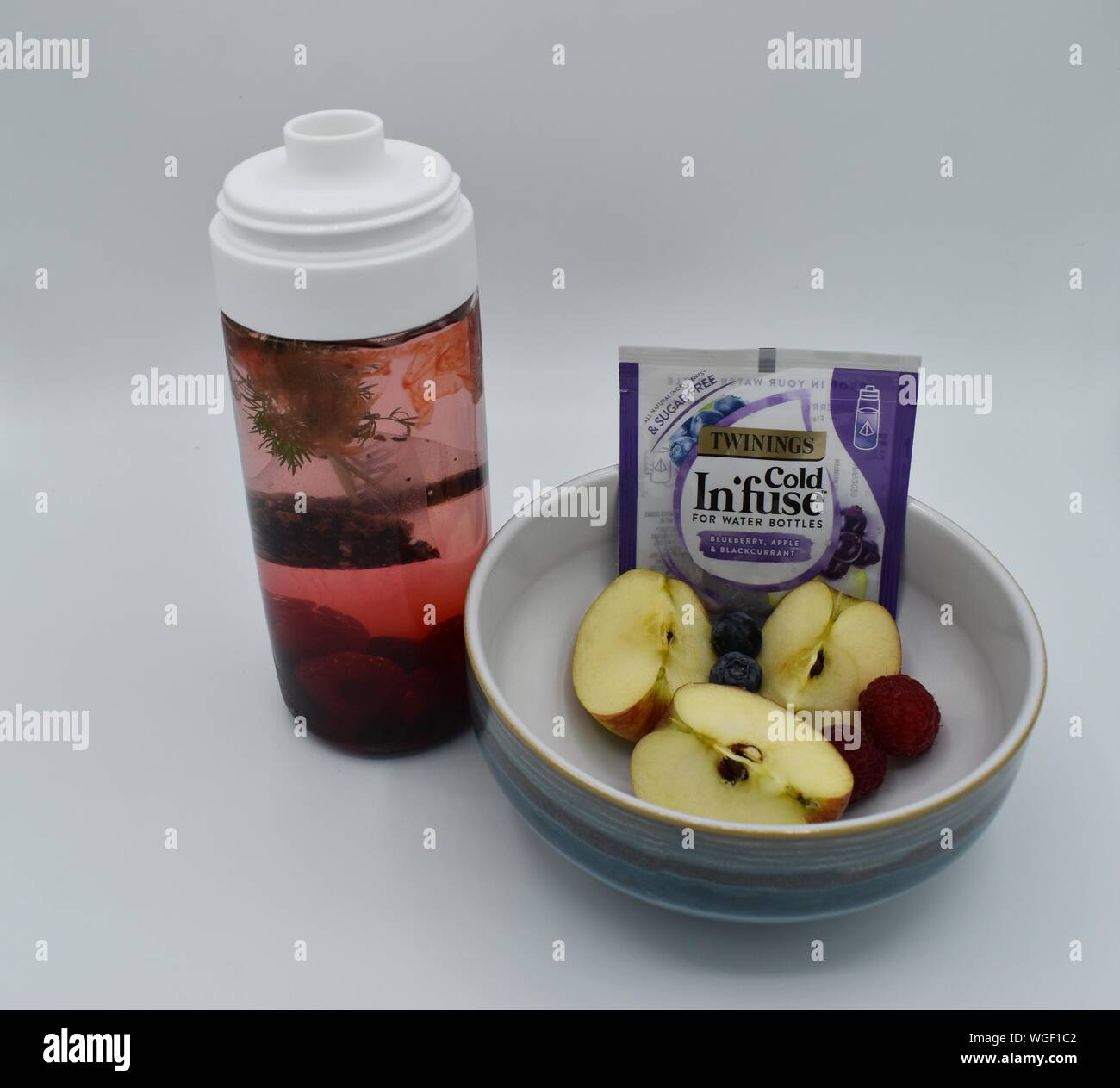 Une infusion froide dans une bouteille d'eau les pommes, bleuets, framboises et d'aneth. Banque D'Images