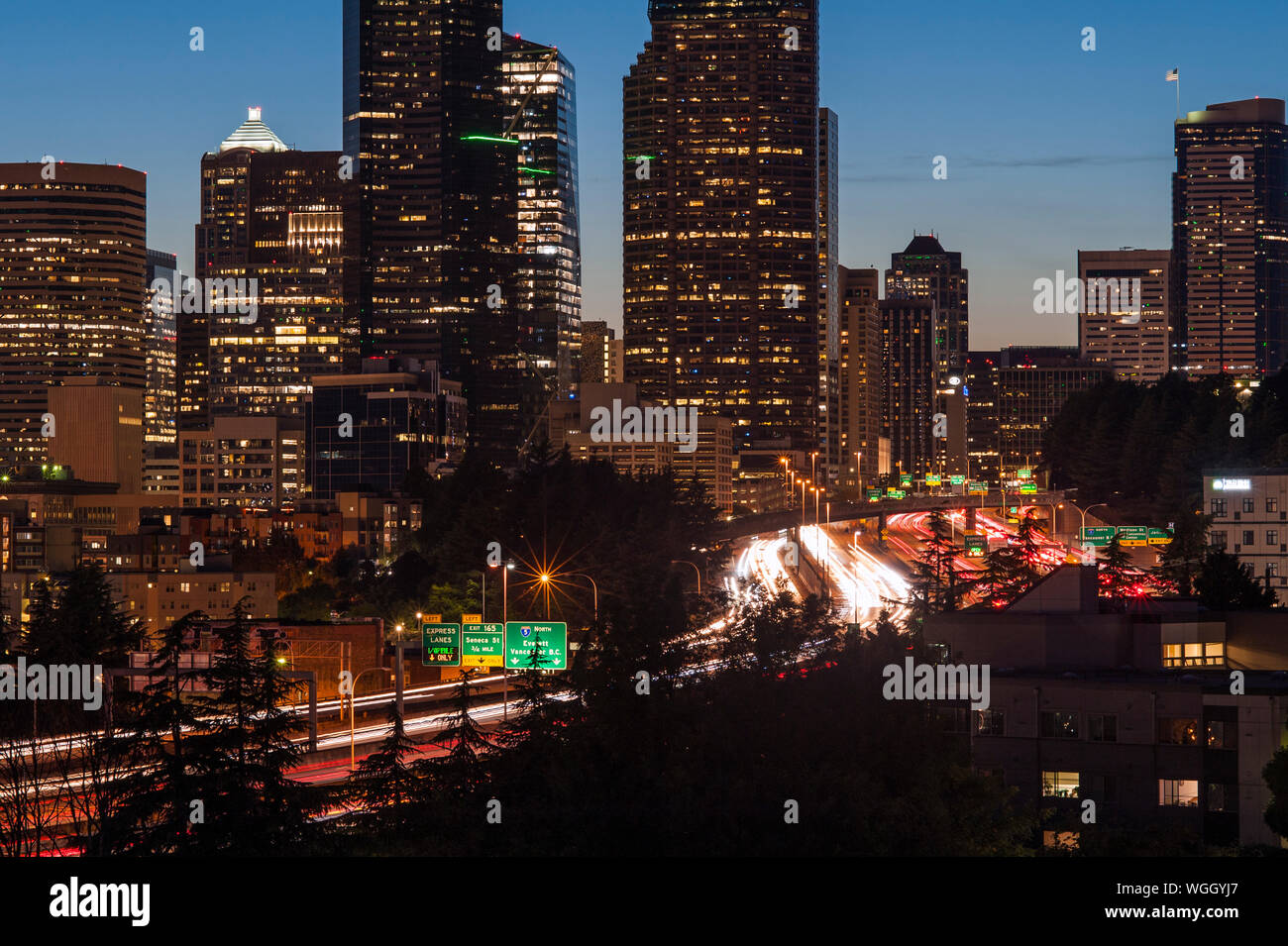 Seattle skyline coucher du soleil avec les lumières et la circulation automobile sur la I-5 Banque D'Images